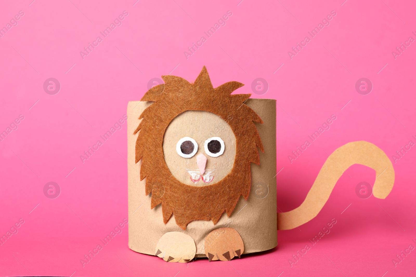 Photo of Toy lion made of toilet paper roll on pink background