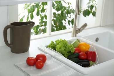 Photo of Many fresh ripe vegetables in kitchen sink