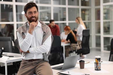 Photo of Team of employees working together in office. Happy man indoors