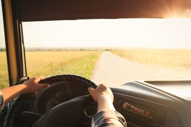 Man driving modern truck on sunny day, closeup