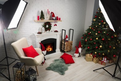 Beautiful Christmas themed photo zone with professional equipment, tree and fireplace in room, above view