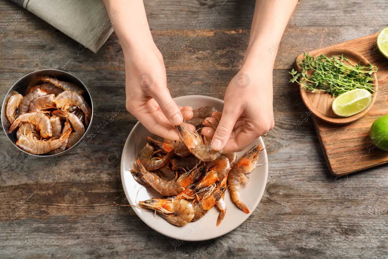 Photo of Woman preparing shrimps at table