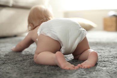 Cute little baby in diaper at home, focus on legs