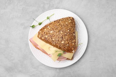 Photo of Delicious sandwich with ham and cheese on light gray table, top view