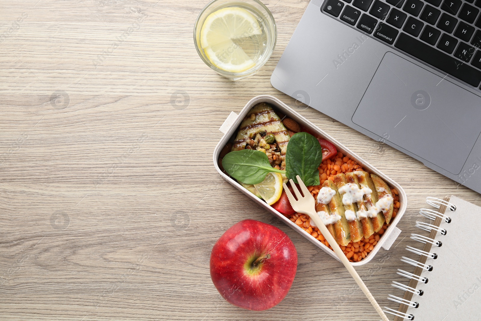 Photo of Healthy products high in vegetable fats near laptop on wooden table, flat lay. Space for text