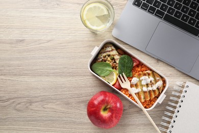 Photo of Healthy products high in vegetable fats near laptop on wooden table, flat lay. Space for text