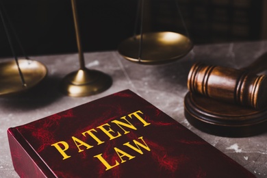 Image of Patent Law book and gavel on grey marble table, closeup