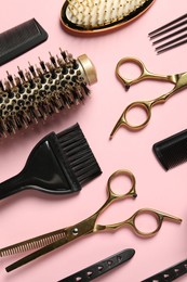 Photo of Professional hair dresser tools on pink background, flat lay