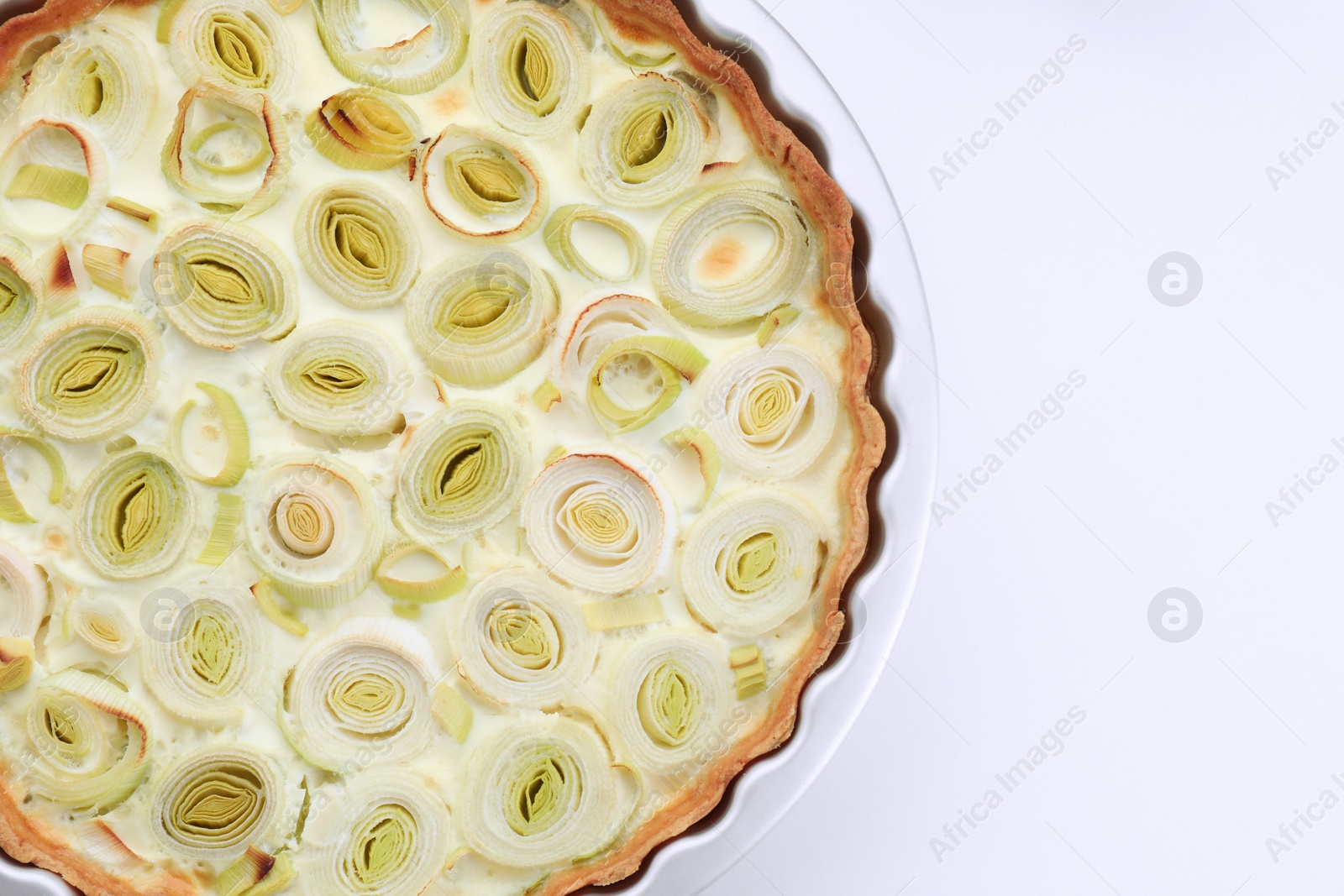 Photo of Freshly baked leek pie on white background, top view. Space for text