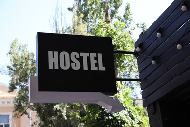 Image of HOSTEL sign board with arrow on building outdoors