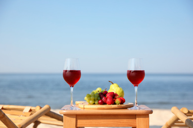 Glasses with wine and fruits on table at resort