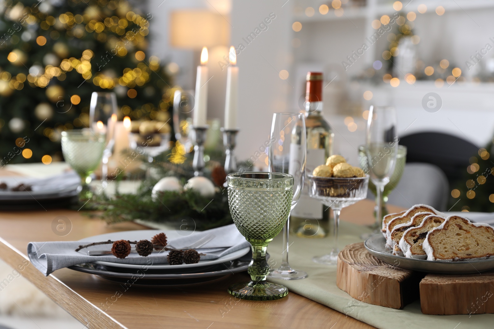 Photo of Christmas table setting with festive decor and dishware in room