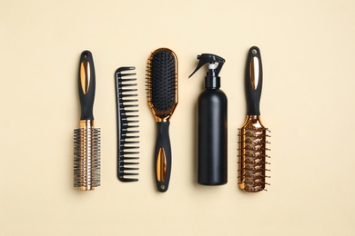 Photo of Flat lay composition with modern hair comb and brushes on beige background
