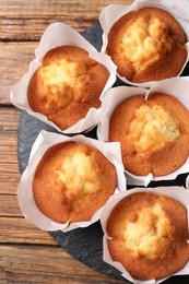 Delicious sweet muffins on wooden table, top view