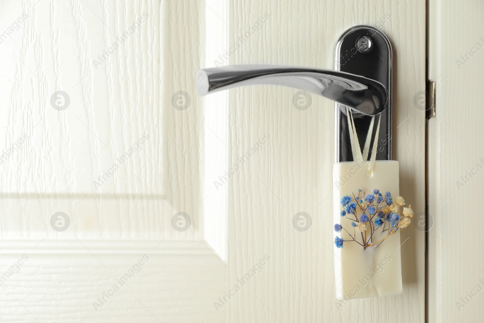 Photo of Scented sachet with flowers hanging on door handle