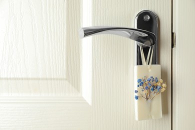 Scented sachet with flowers hanging on door handle