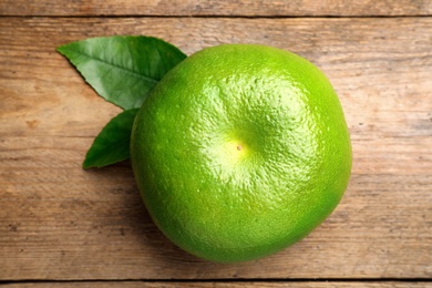 Photo of Fresh ripe sweetie fruit on wooden table, top view