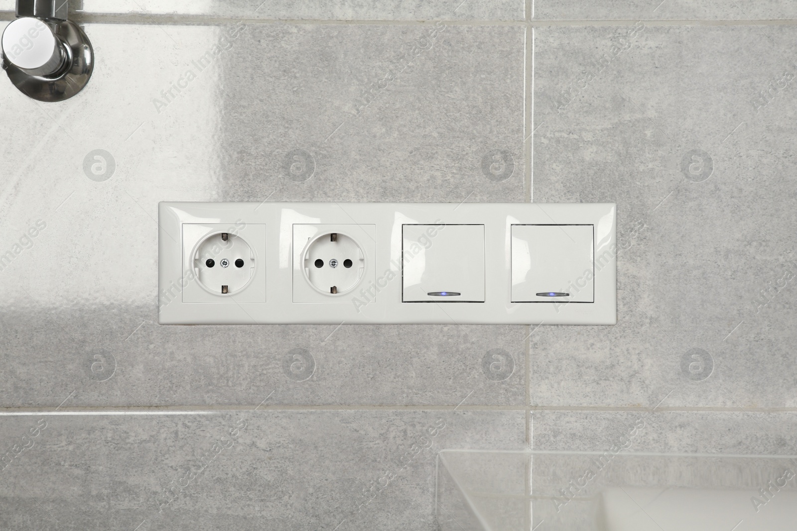 Photo of Light switches and power sockets on wall indoors