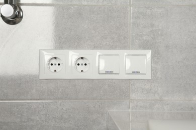 Light switches and power sockets on wall indoors