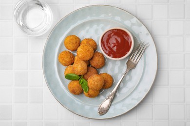 Photo of Delicious fried tofu balls with basil and sauce on white tiled table, top view