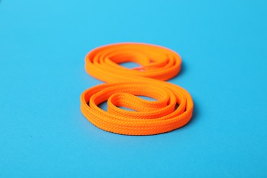 Photo of Orange shoe lace on light blue background