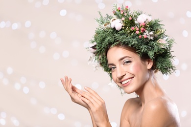 Photo of Happy young woman wearing wreath against blurred lights. Space for text