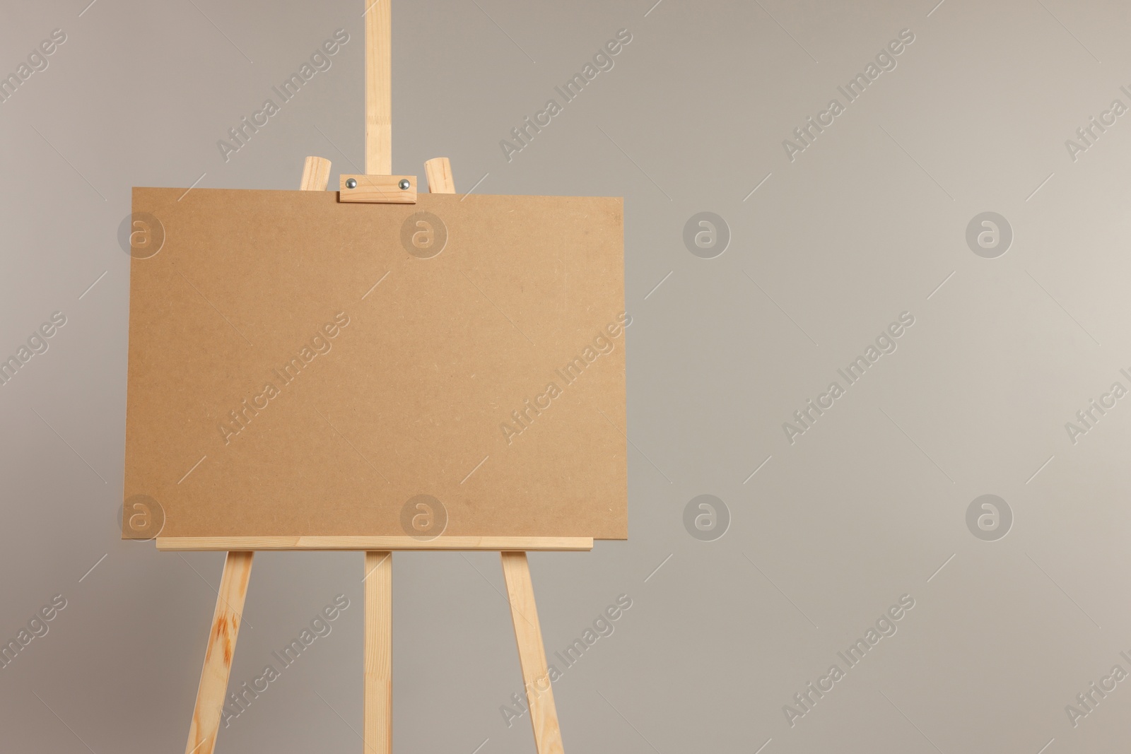 Photo of Wooden easel with blank board on grey background. Space for text