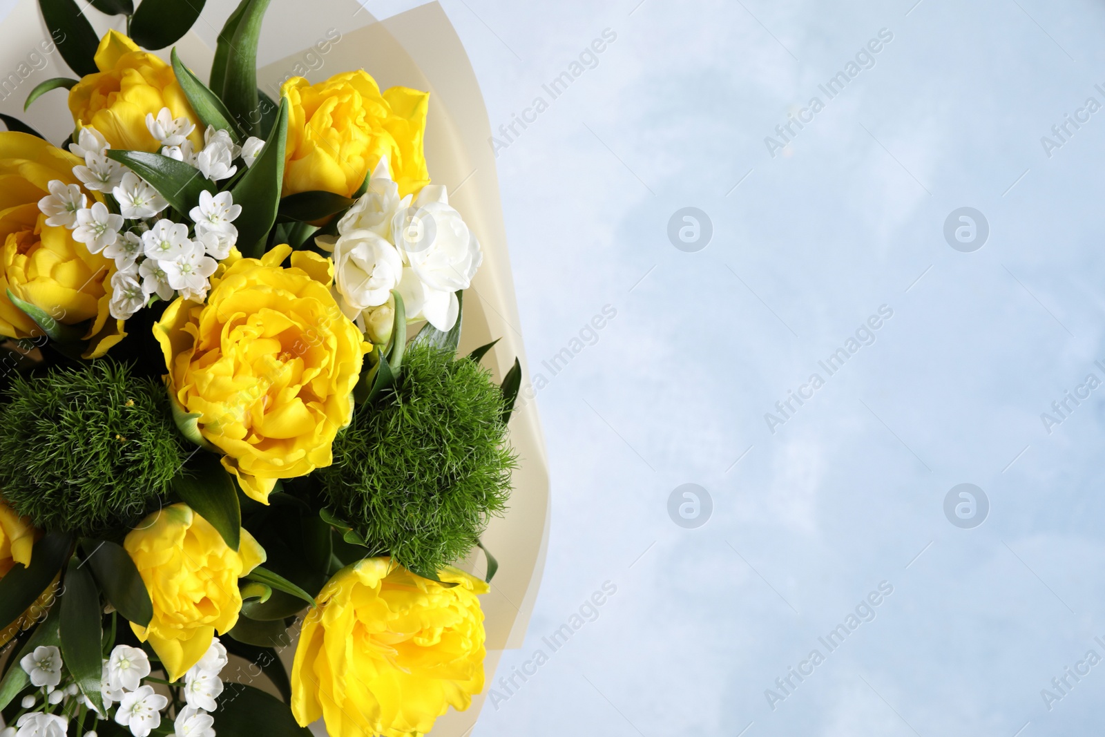 Photo of Beautiful bouquet with peony tulips on light blue background, closeup. Space for text