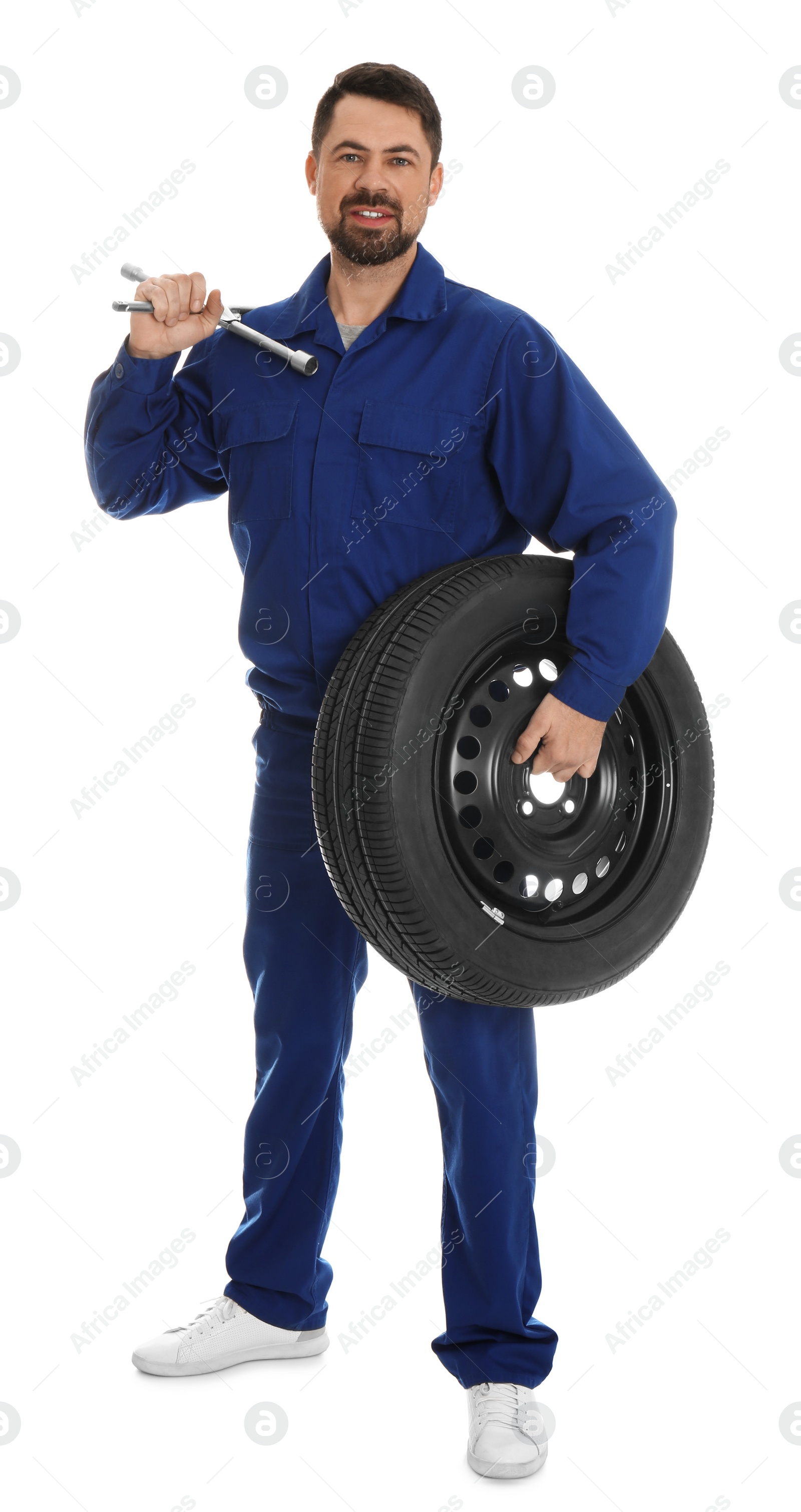 Photo of Full length portrait of professional auto mechanic with lug wrench and wheel on white background