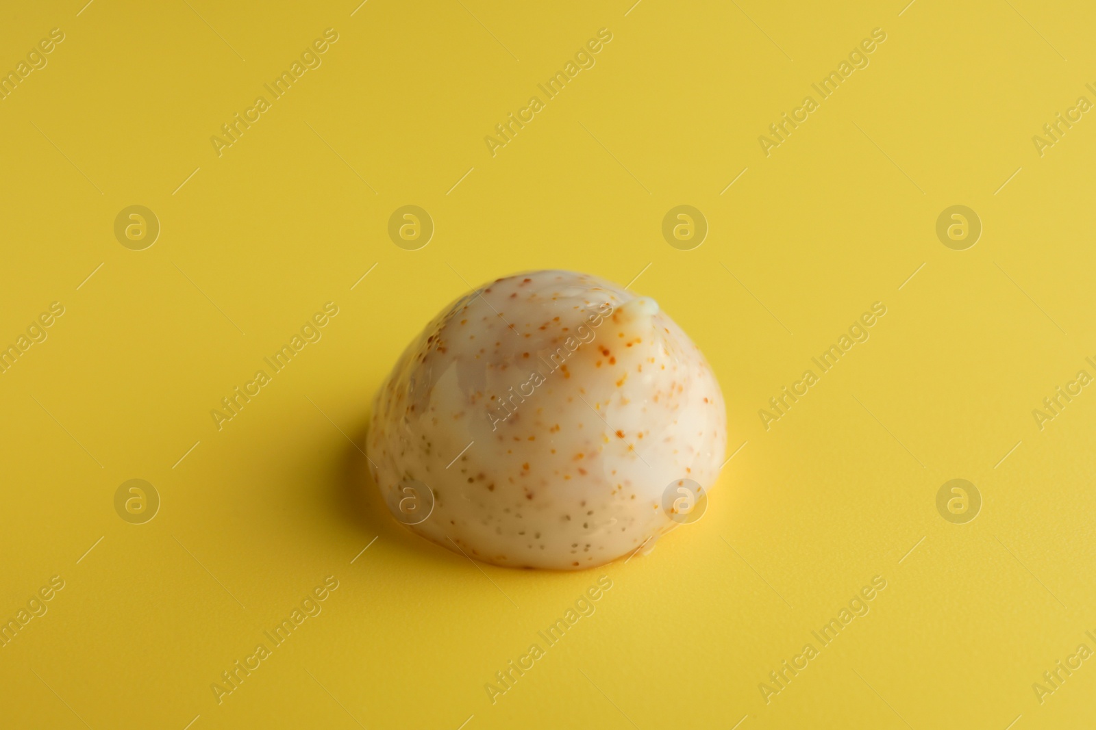 Photo of Sample of face scrub on yellow background