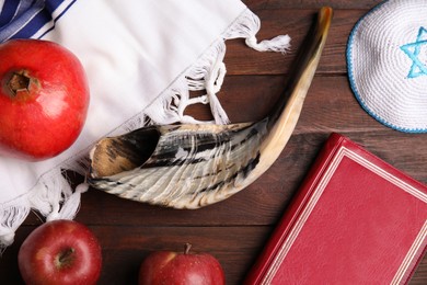 Flat lay composition with Rosh Hashanah holiday symbols on wooden table