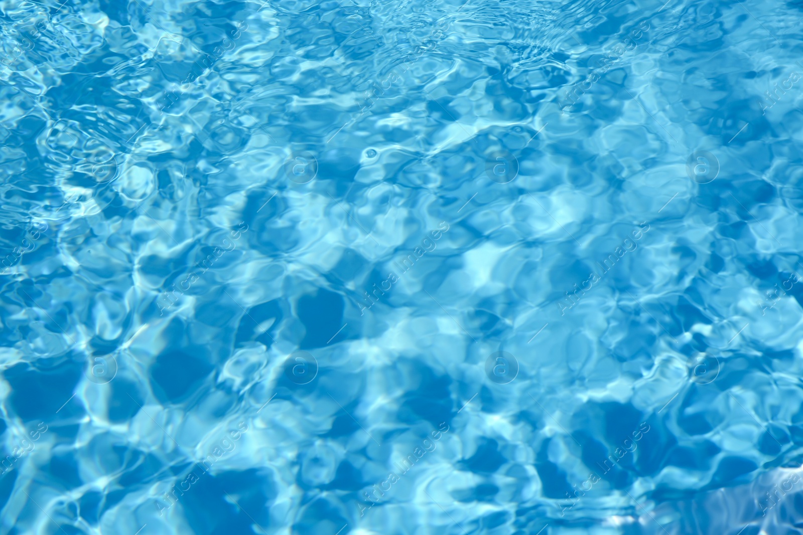 Photo of Texture of blue water in swimming pool as background, closeup