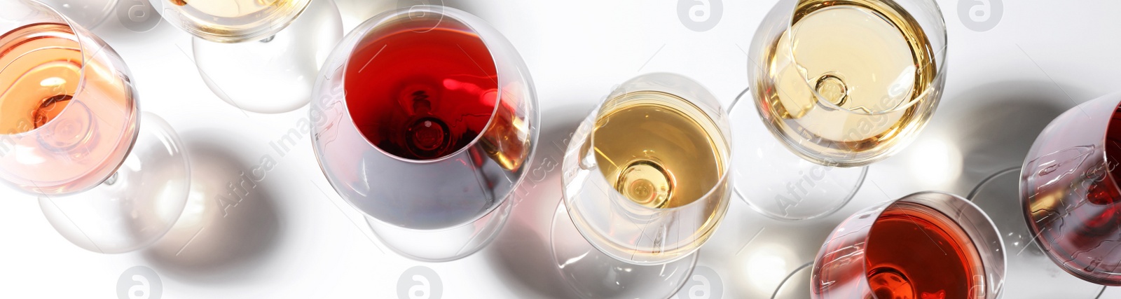 Image of Glasses with different wines on white background, top view. Banner design