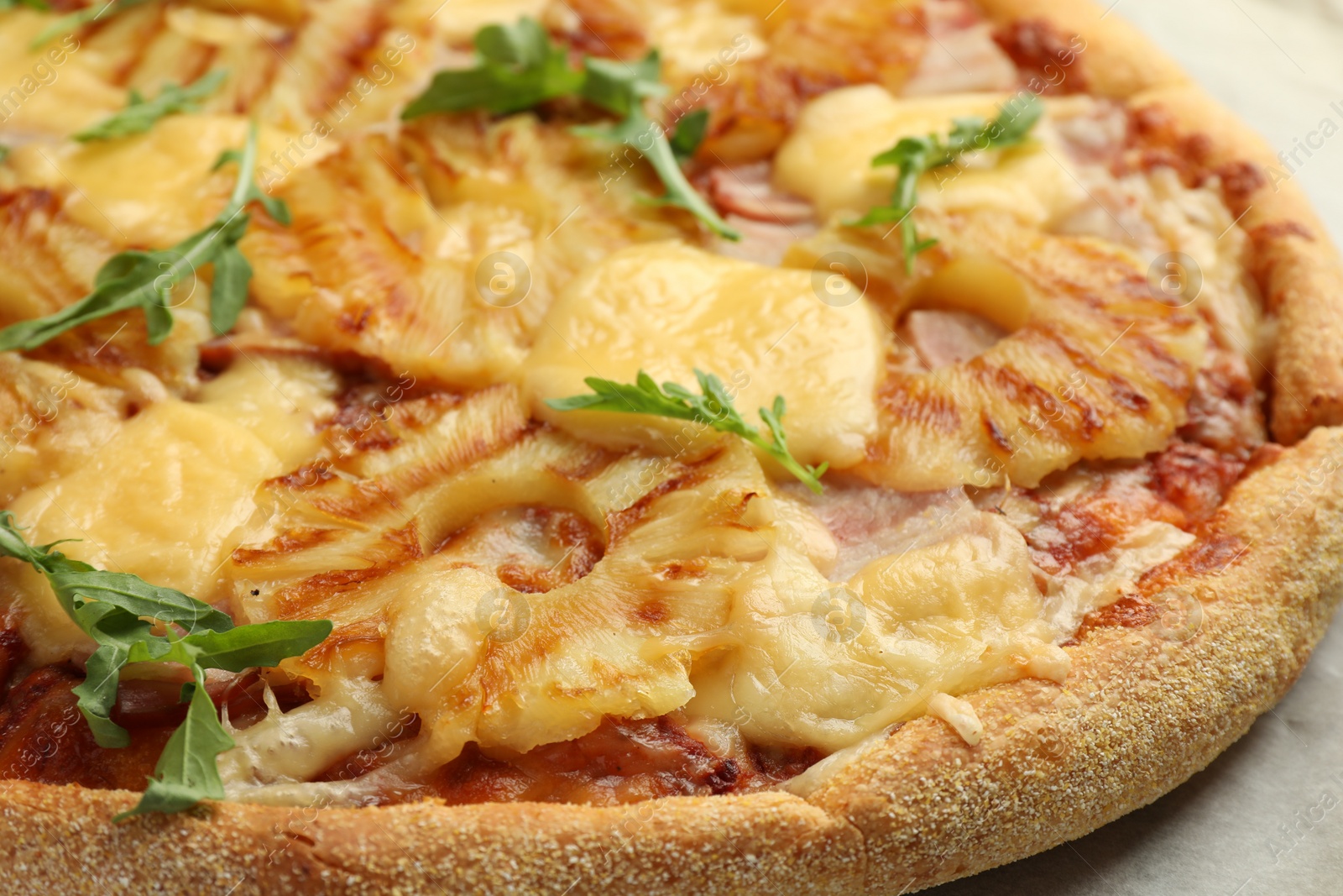 Photo of Delicious pineapple pizza with arugula on table, closeup