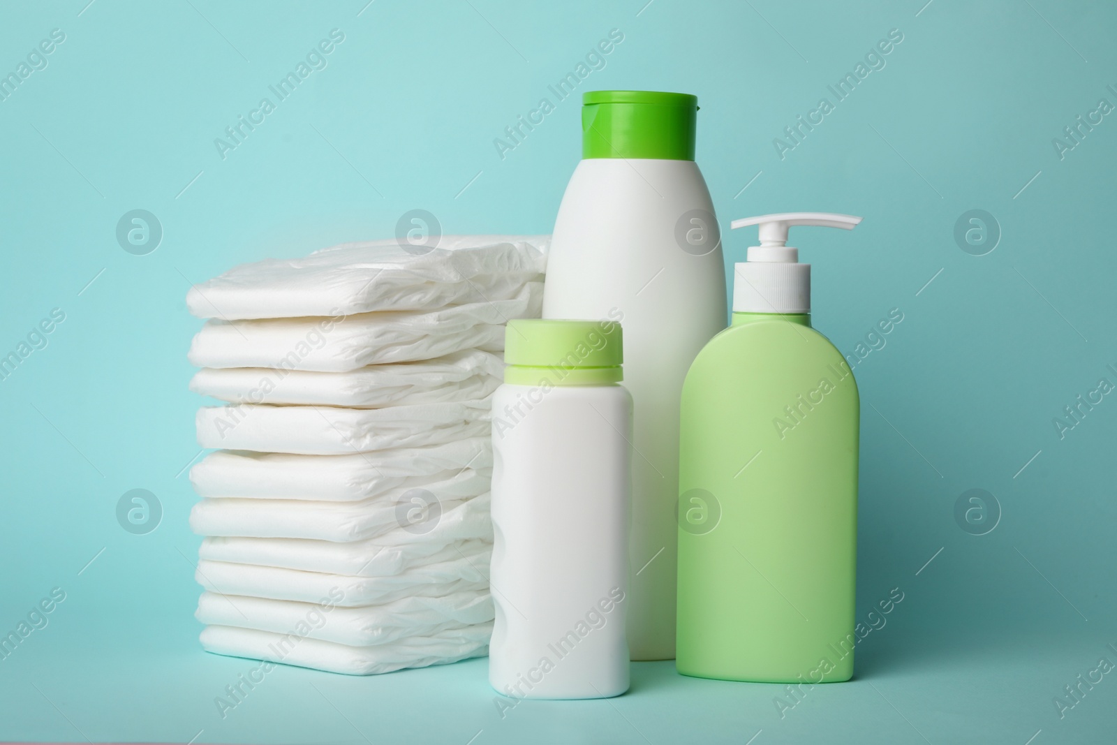 Photo of Diapers and baby accessories on light blue background