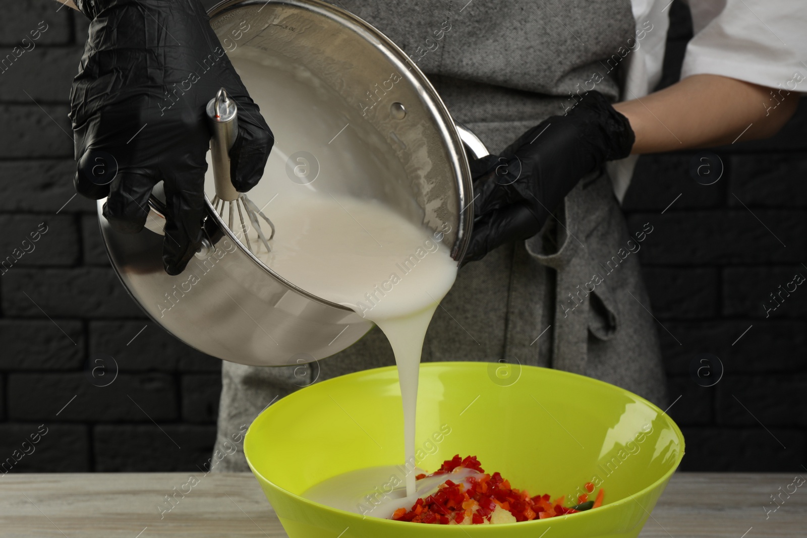 Photo of Woman preparing spicy cabbage kimchi at wooden table indoors, closeup