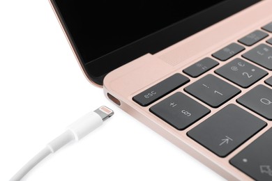 Photo of USB cable with lightning connector and laptop on white background