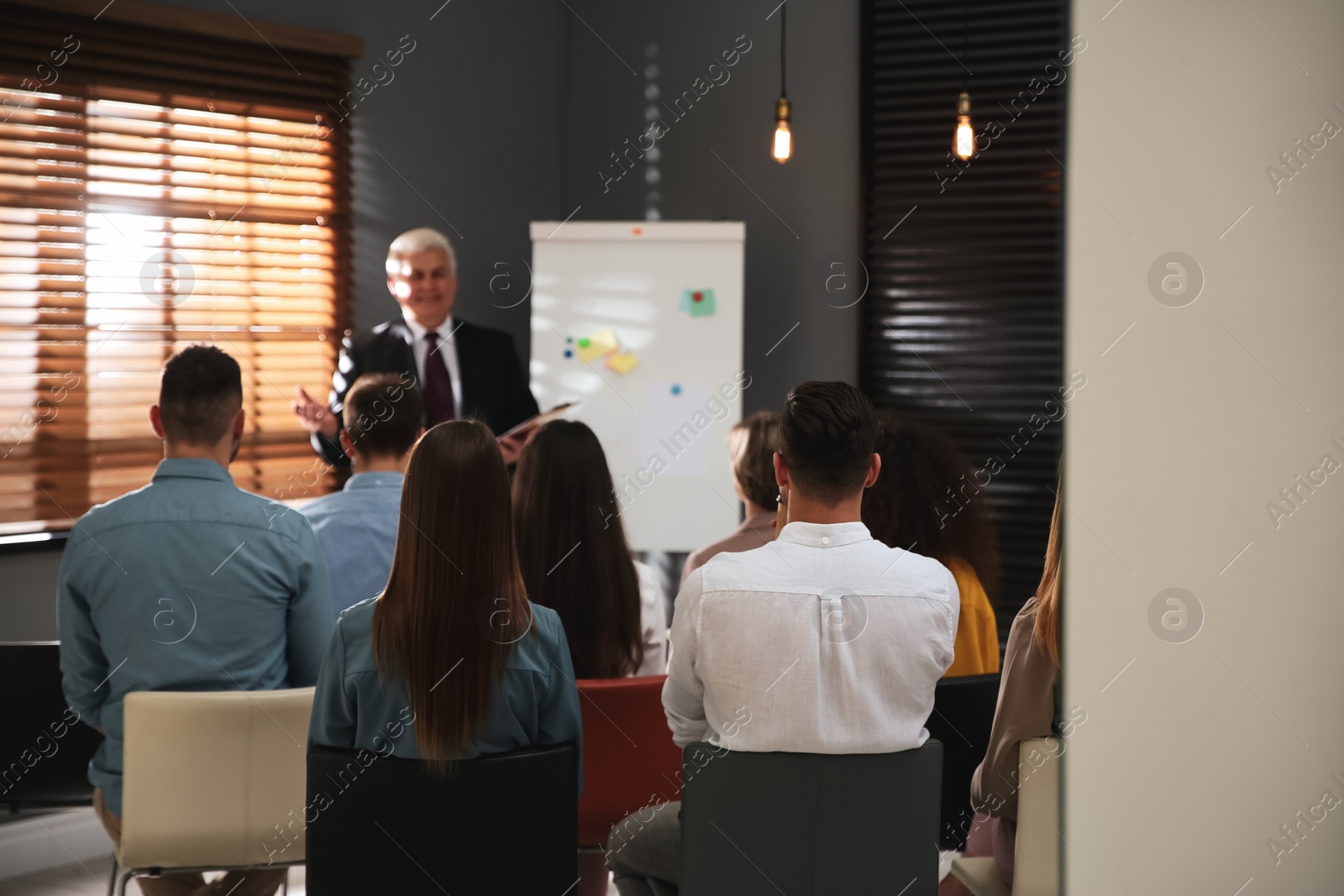 Photo of Business trainer answering questions at seminar in conference hall