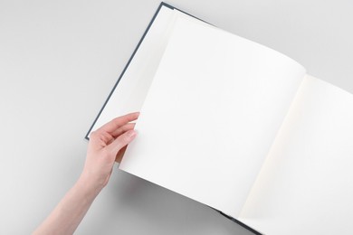 Woman with open photo album at light table, top view. Space for text