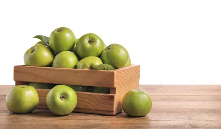 Ripe green apples in crate on wooden table against white background. Space for text