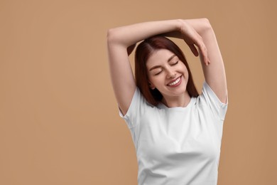 Photo of Portrait of smiling woman on beige background. Space for text