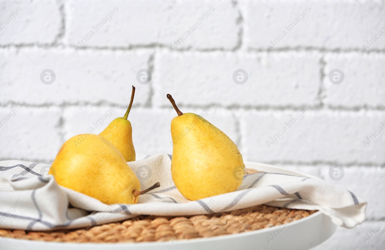 Photo of Ripe pears on table near brick wall