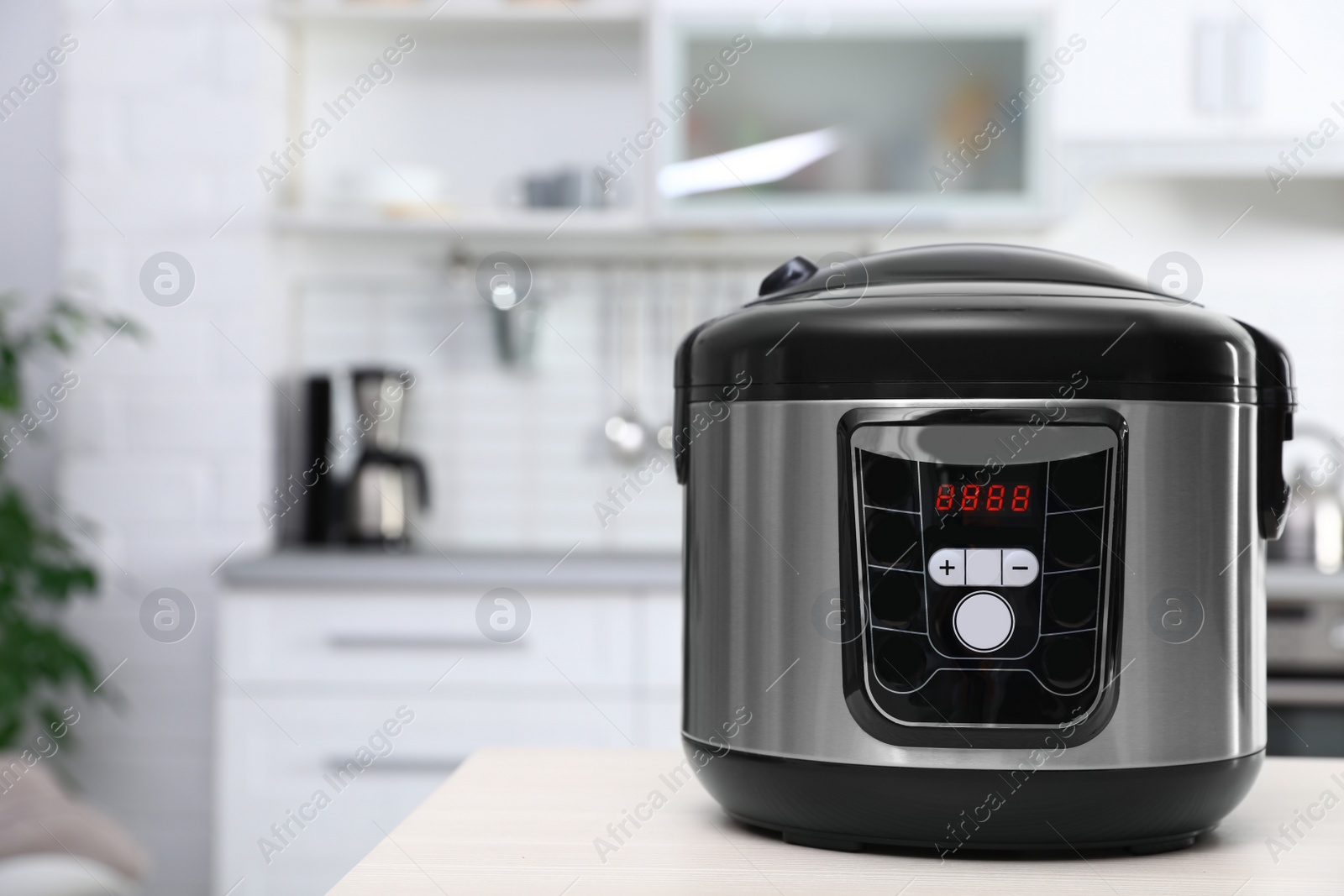 Photo of Modern multi cooker on table in kitchen. Space for text