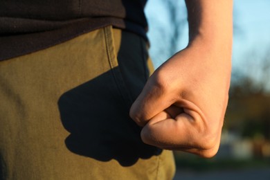 Photo of Angry man with clenched fist outdoors, closeup
