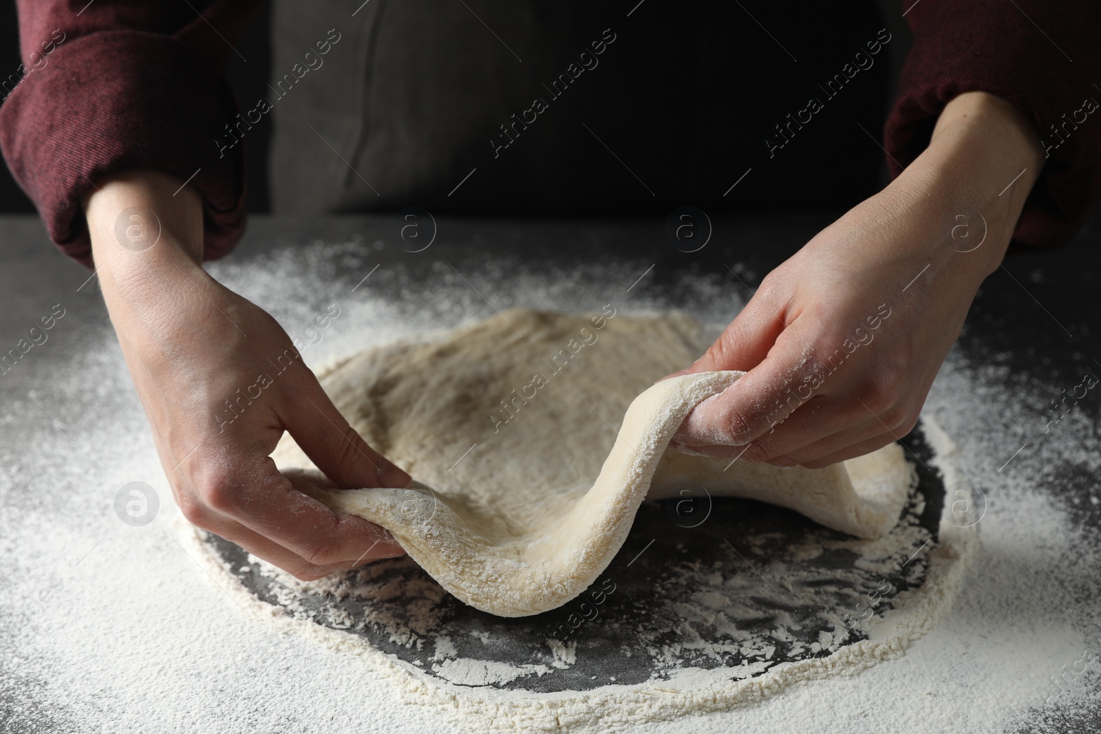 Photo of Woman kneading pizza dough at table, closeup