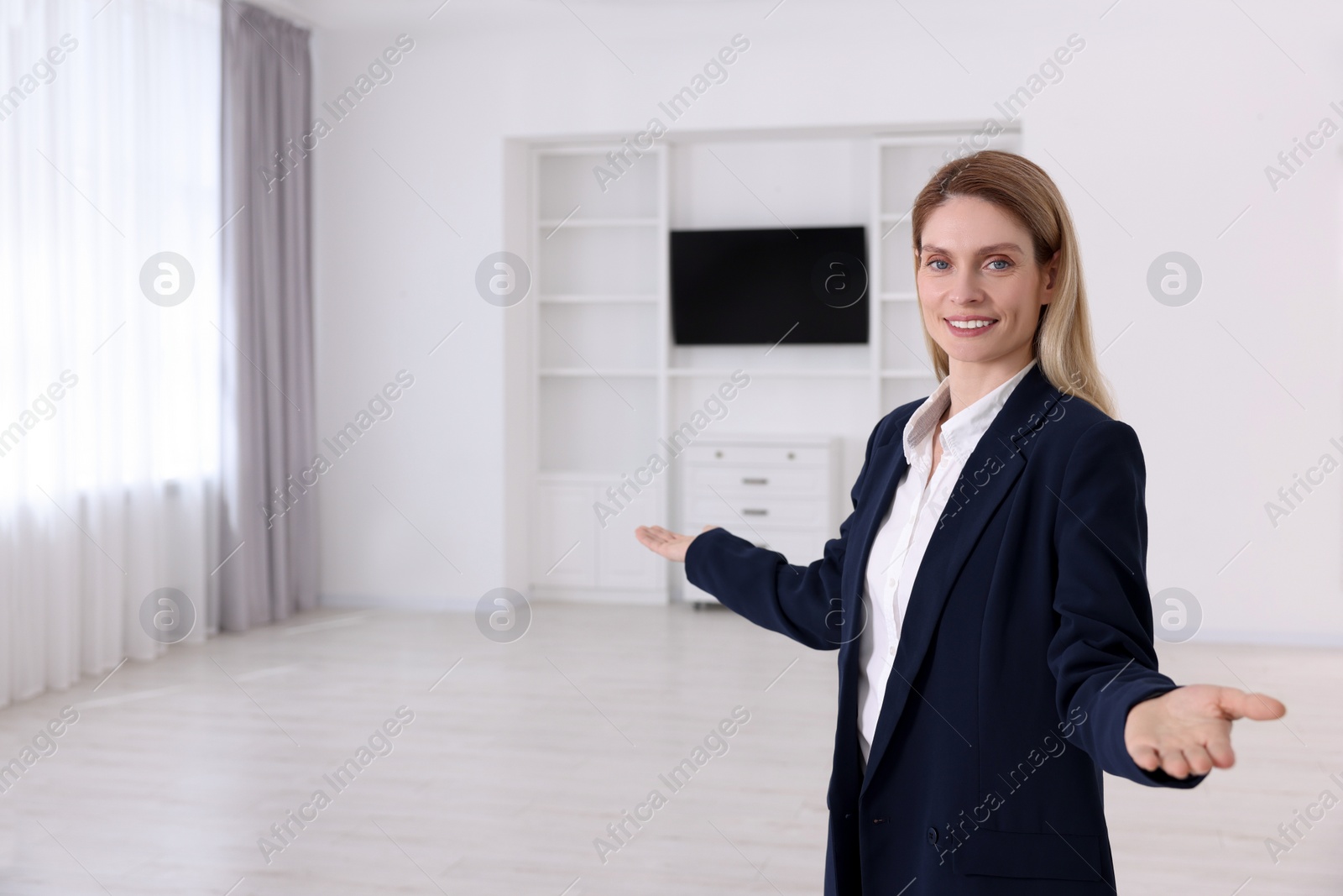 Photo of Happy real estate agent showing new house. Space for text