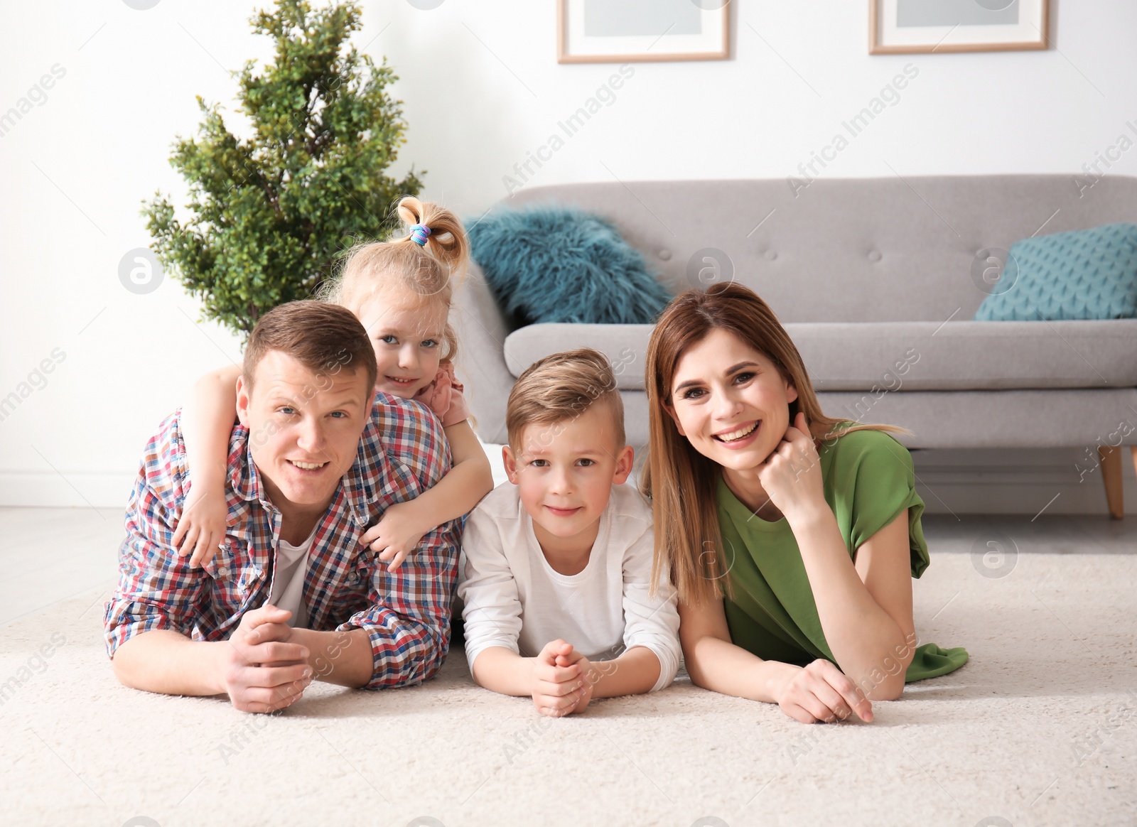 Photo of Happy family lying on cozy carpet at home