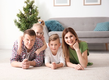 Happy family lying on cozy carpet at home