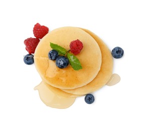 Tasty pancakes with berries and honey isolated on white, top view