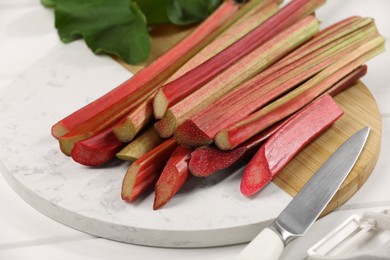 Many cut rhubarb stalks on white table, closeup